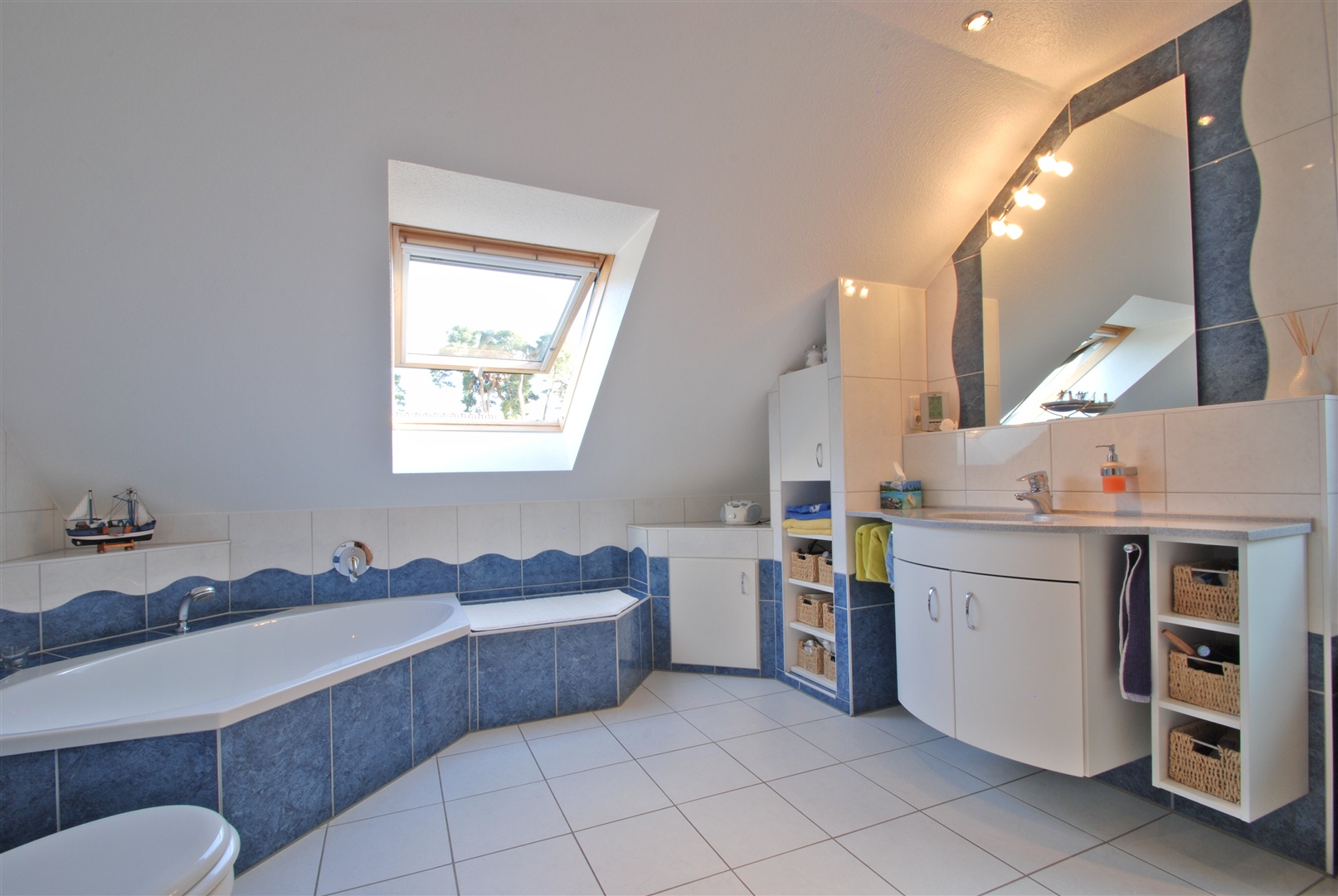 Hauptbadezimmer mit Fußbodenheizung. Der Raum bietet: Große Badewanne, Waschtisch, WC, bodengleiche Dusche mit Glasabtrennung und Übergröße sowie zwei Fenster. Das Dachflächenfenster kann elektrisch mit einem Außenrollladen verdunkelt werden. - Oliver Reifferscheid - Immobilienmakler Darmstadt