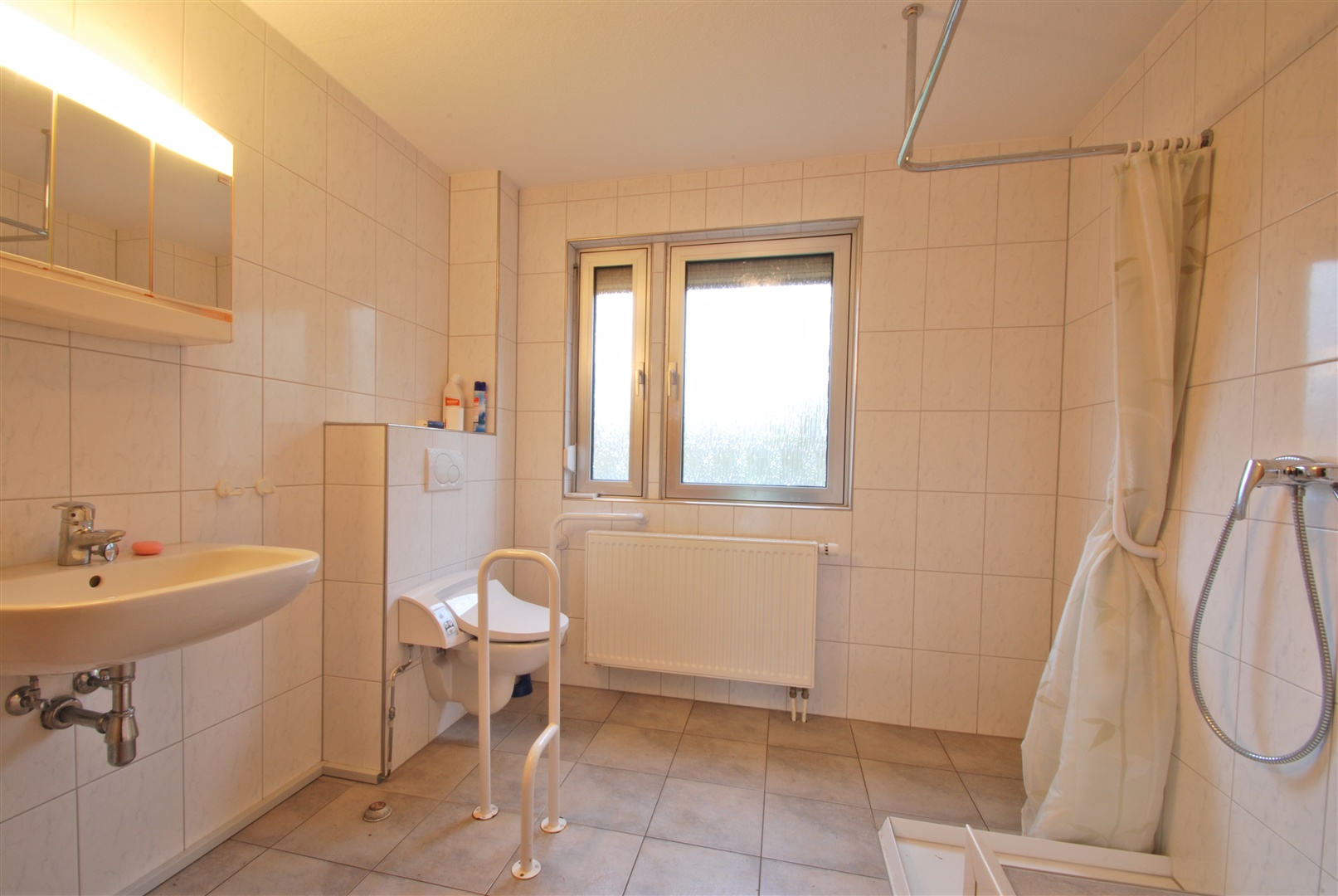Für Menschen mit Behinderung orientiertes Badezimmer mit Tageslicht und bodengleicher Dusche. - Oliver Reifferscheid - Immobilienmakler Darmstadt