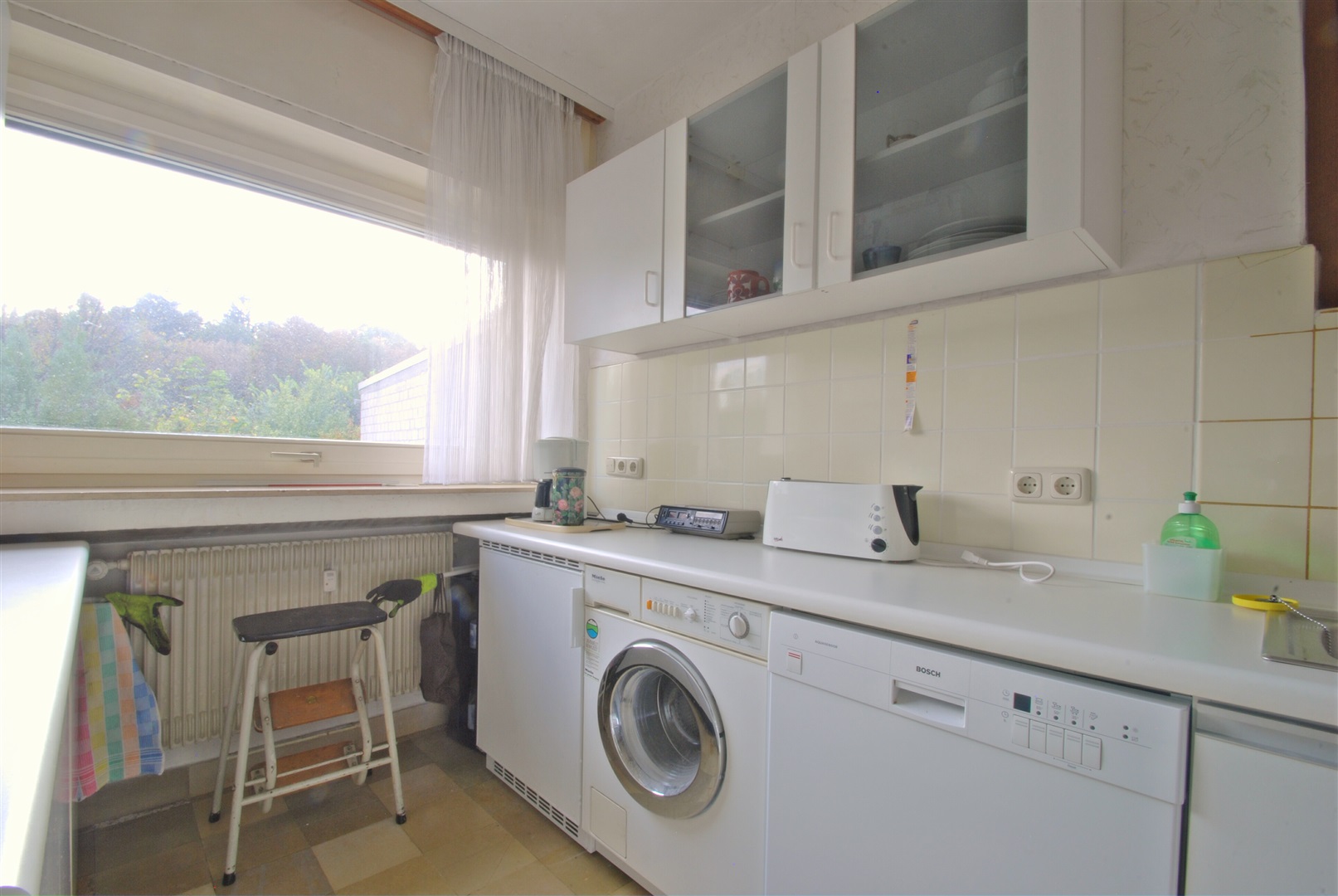 Küchenraum mit Blick in den Südgarten. Die Wände zum Esszimmer und WC sind vermutlich nicht tragend, so dass leicht ein größerer Koch-, Essraum mit halboffenem Wohnzimmer entstehen kann. - Oliver Reifferscheid - Immobilienmakler Darmstadt