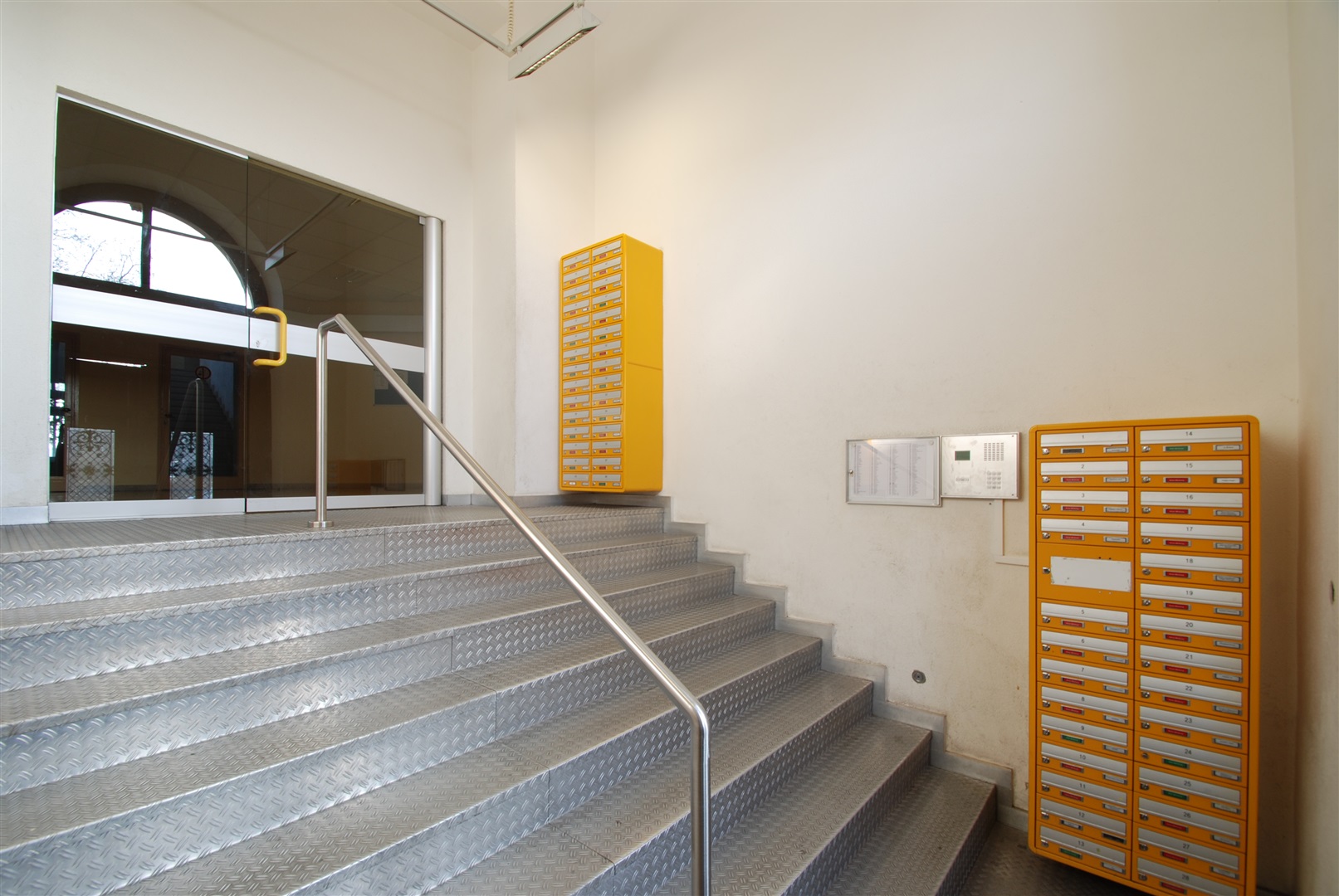 Funktionaler Eingangsbereich mit vielen Briefkästen die trocken und geschützt stehen. Die Glastür im Hintergrund kann mittels Schlüssel oder Pin Code geöffnet werden - Oliver Reifferscheid - Immobilienmakler Darmstadt