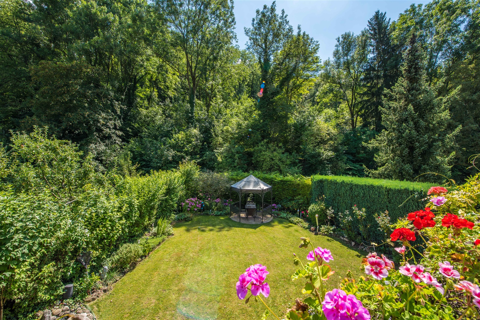 Blick ins grüne vom Wohnzimmerbalkon. Der Garten ist mit hohen Hecken rundherum eingewachsen. Besonders schön: Sie haben nur rechts und links Nachbarn, vor und hinter dem Haus ist alles schön grün und ruhig. - Oliver Reifferscheid - Immobilienmakler Darmstadt