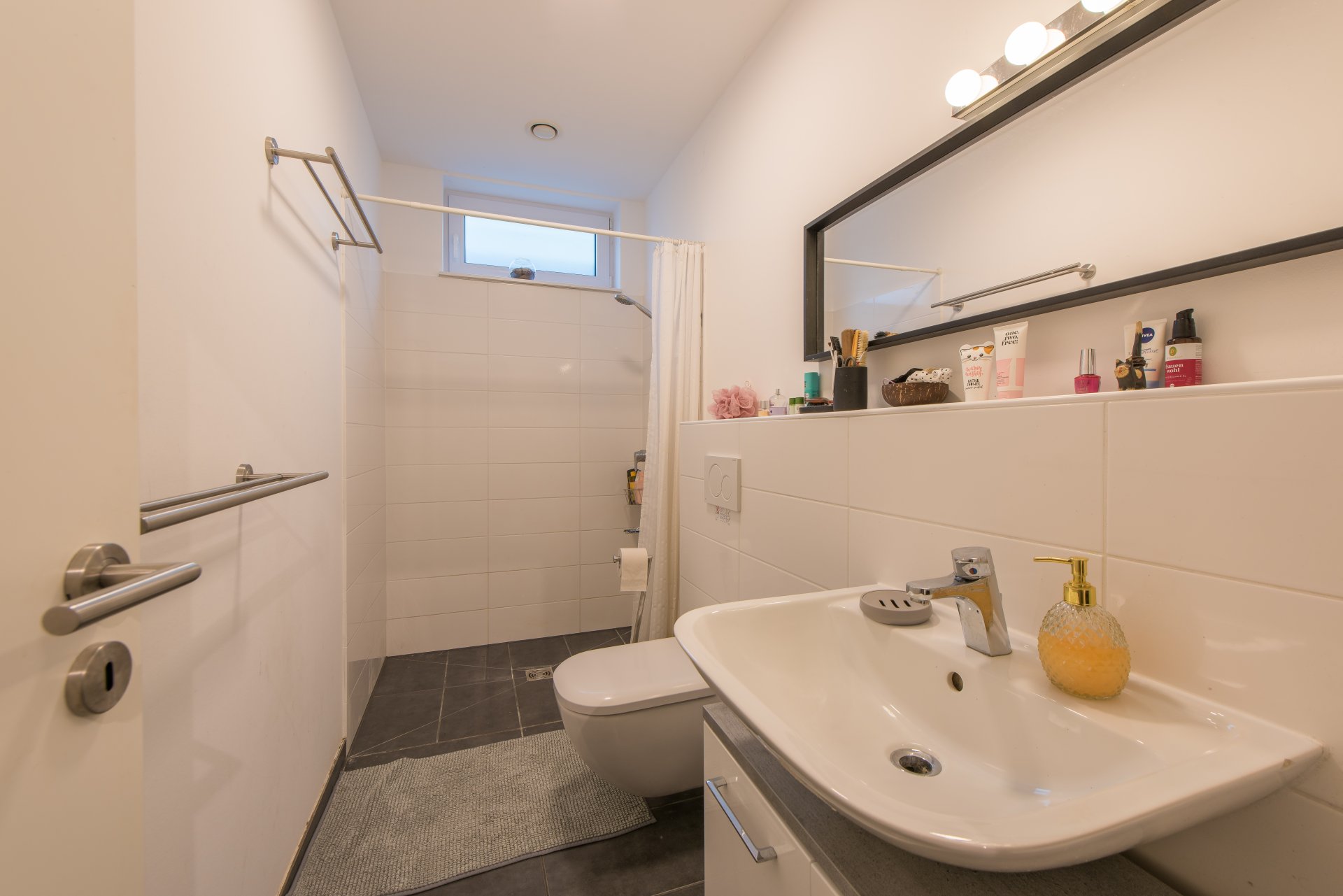 Modernes Bad mit Tageslicht, bodengleicher Dusche, Waschbecken und WC und Fußbodenheizung - Oliver Reifferscheid - Immobilienmakler Darmstadt