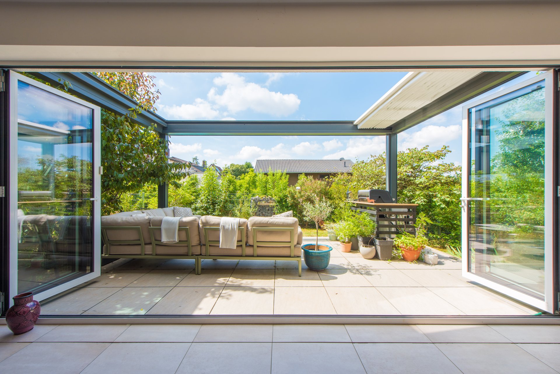 Fast raumbreite, deckenhohe Fenster-Faltanlage vom Wohnzimmer zum Südgarten hin - Oliver Reifferscheid - Immobilienmakler Darmstadt