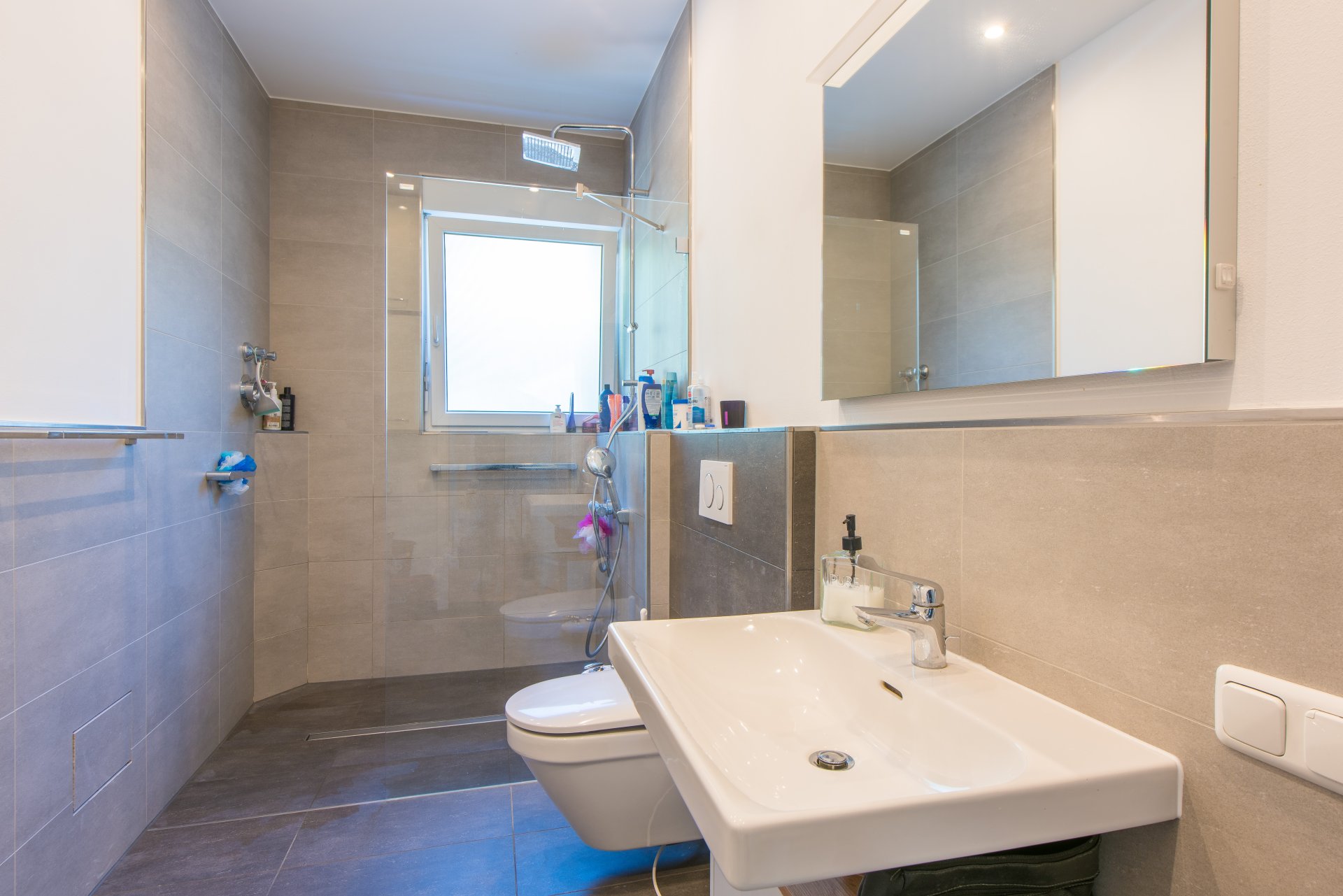 Modernes Bad mit Tageslicht, bodengleicher, großer Dusche, WC und Waschtisch - Oliver Reifferscheid - Immobilienmakler Darmstadt